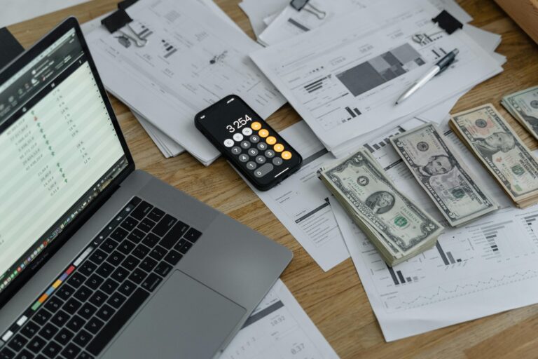 laptop money and calculator on a desk